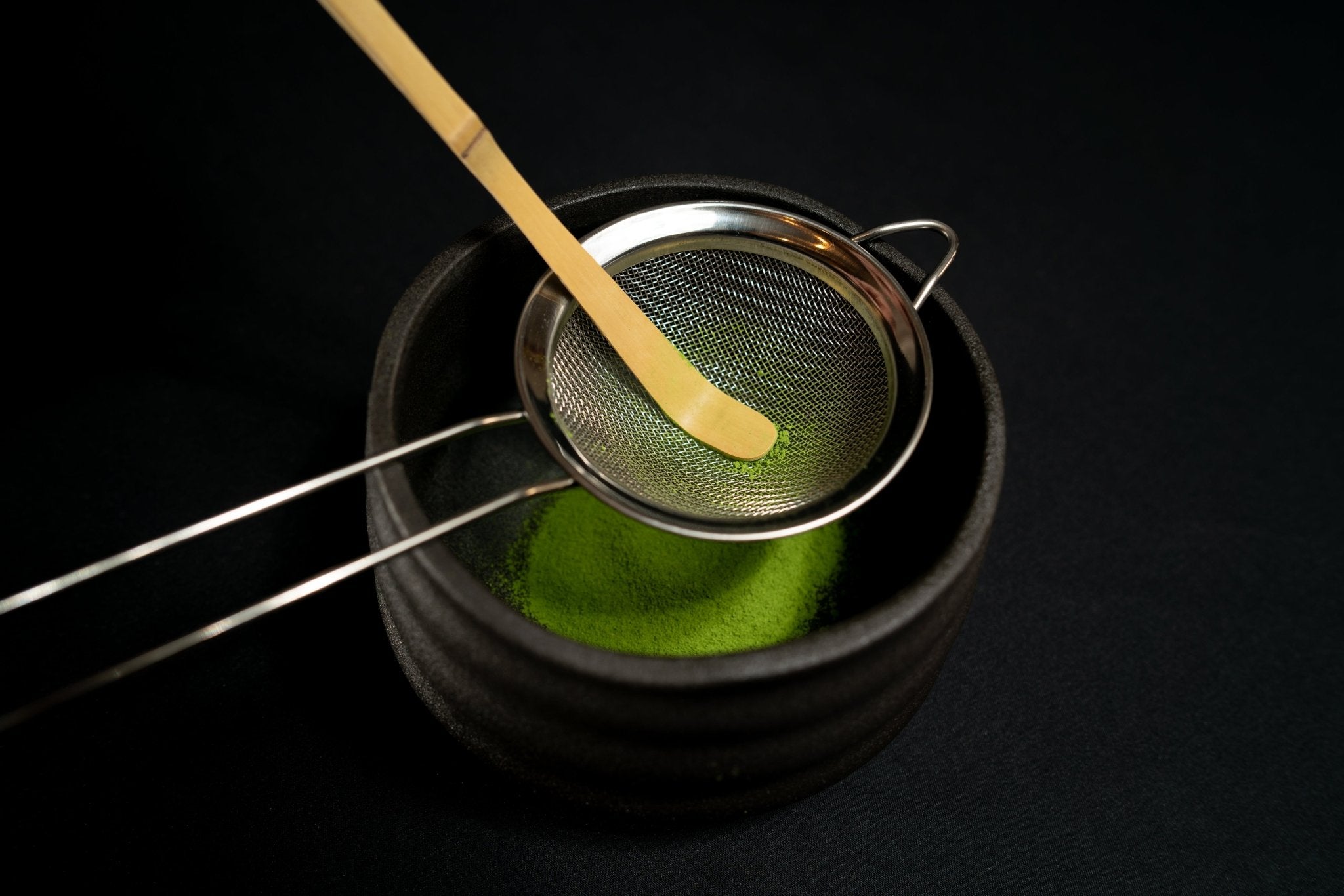 Tamisage du thé matcha avec spatule bambou et une passoire thé matcha dans un bol chasen japonais