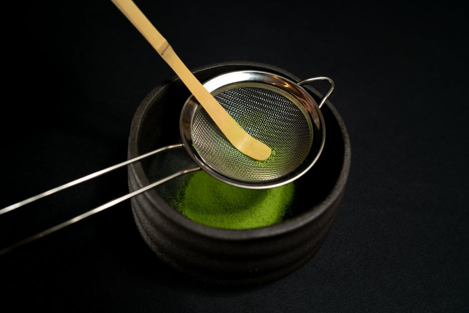 Tamisage du thé matcha avec spatule bambou et une passoire thé matcha dans un bol chasen japonais